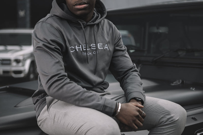 Model Wearing Caps Of Steel Grey with Silver Embroidery - Chelsea Truck Co Hoodie Near Kahn Building